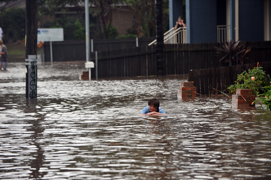 Flood water crosses the intersection of George Street and Susan Ave, Warilla, during flash flooding across the Illawarra region.